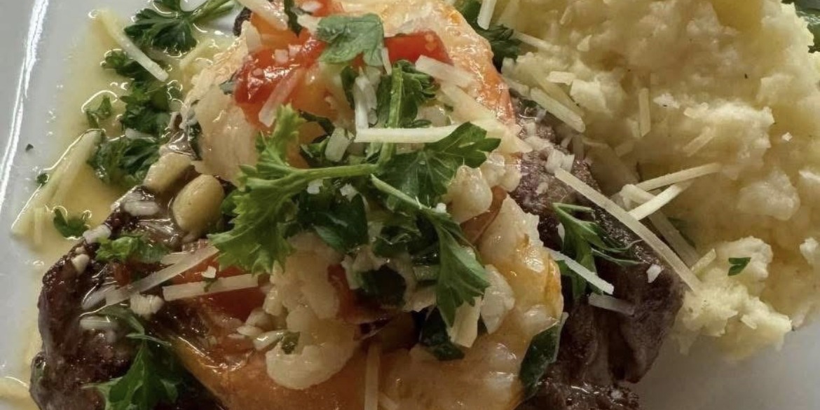 Grilled steak topped with shrimp, with mashed potatoes
